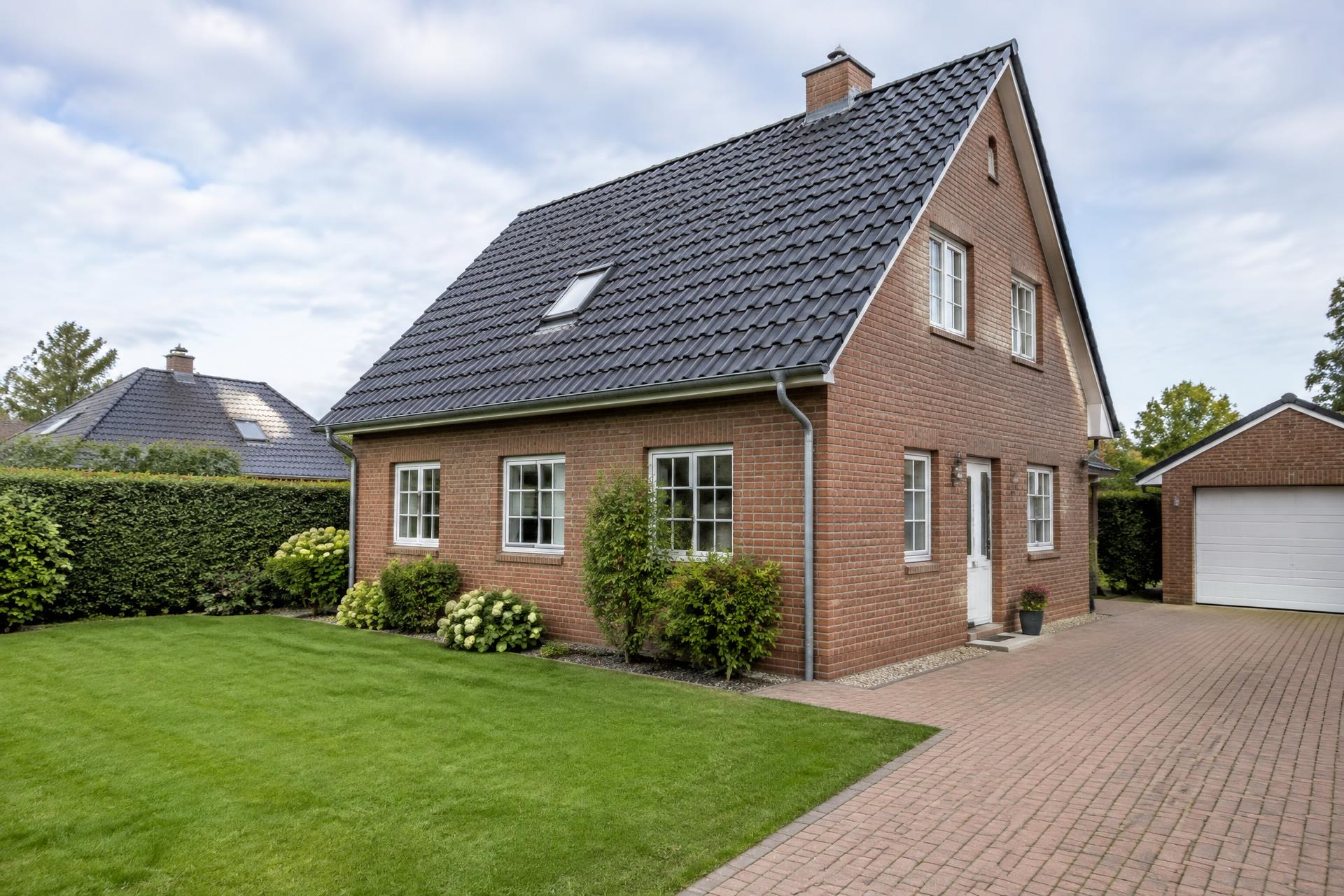 Gepflegtes Haus in Schleswig-Holstein mit frisch gemähtem Rasen und sauberer Auffahrt